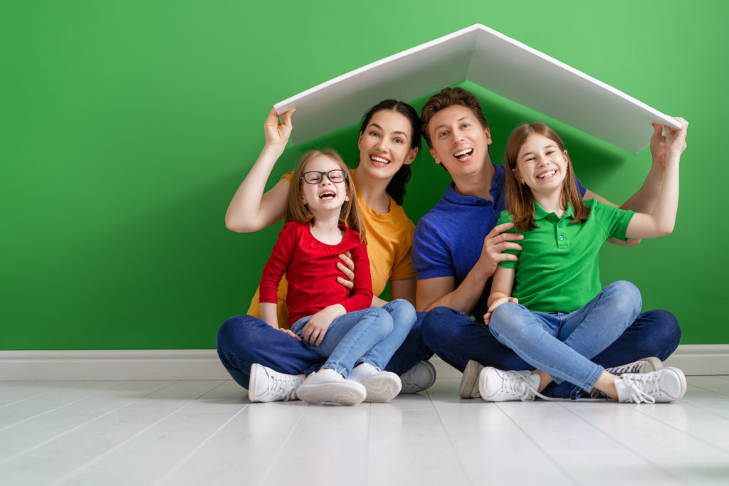 Mother, father and children girls in the house with a symbol of roof. Concept of housing for young family.
